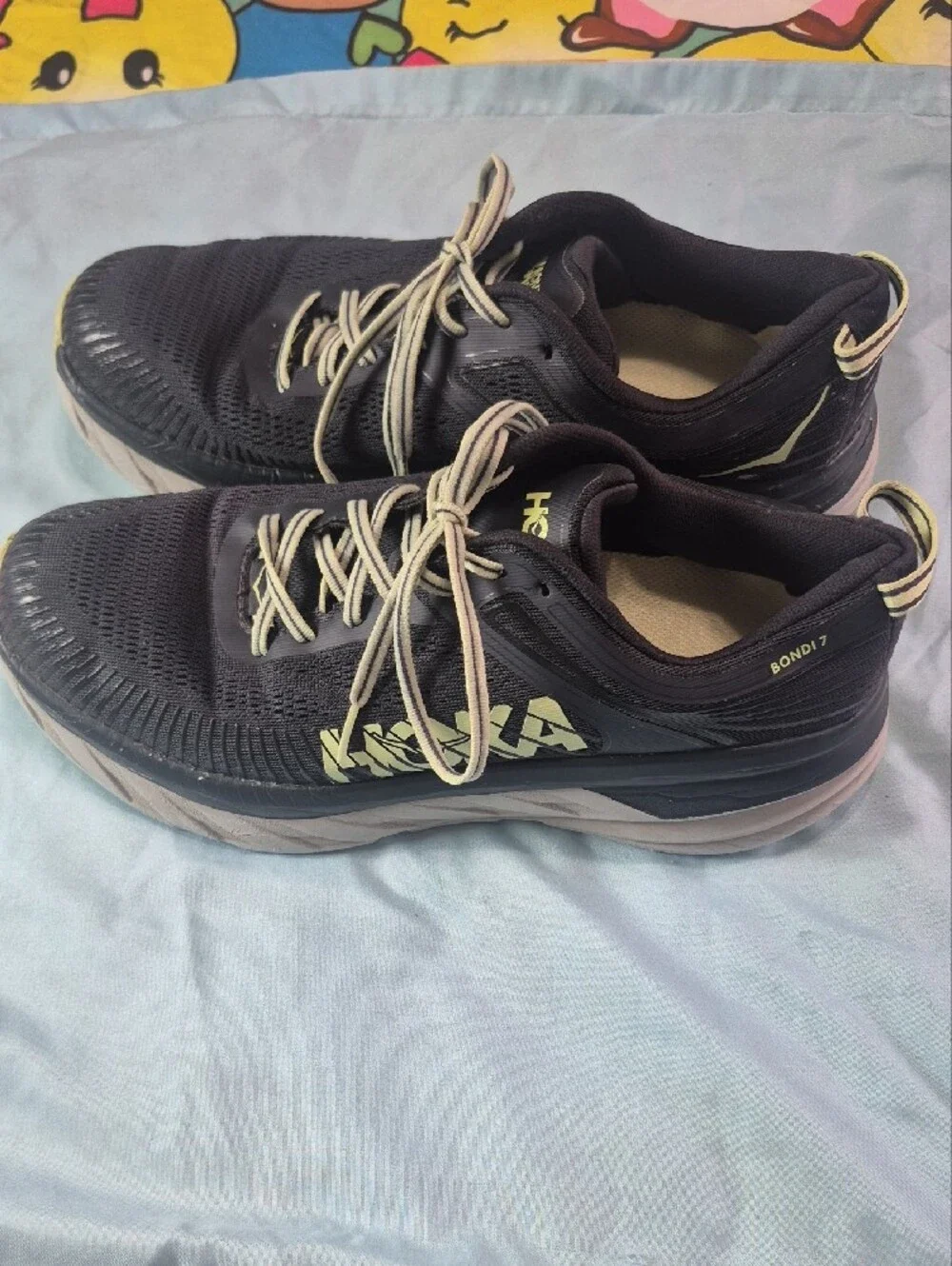 Hoka black running shoes with pale yellow logo